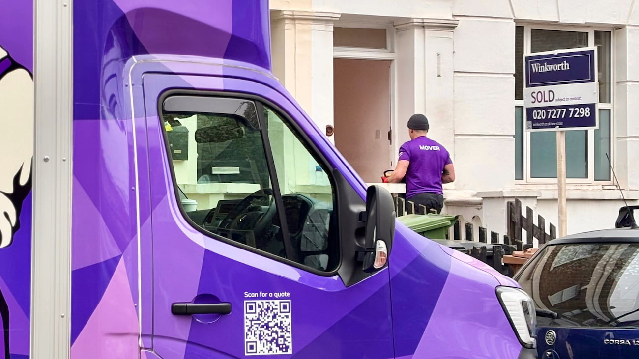 Finest Van removals specialist carrying a box into a South London property during a house move