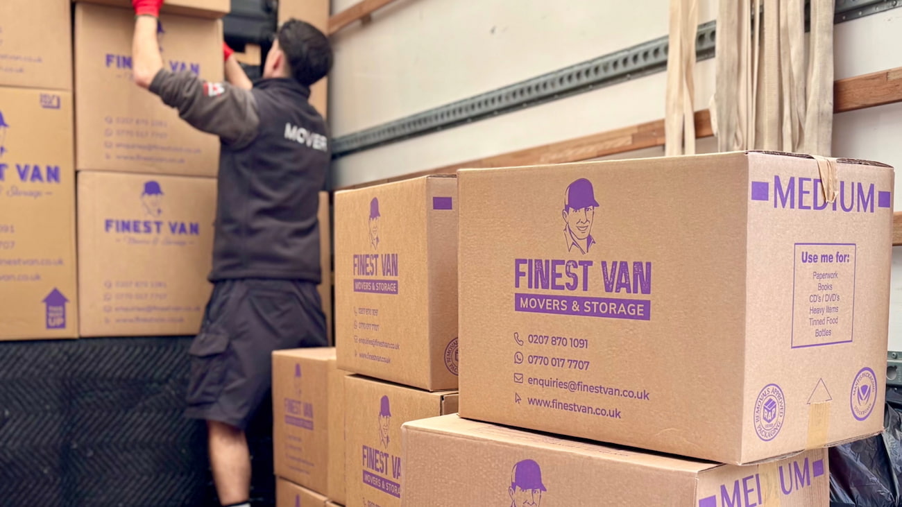 Mover loading moving boxes into a van for a UK house move