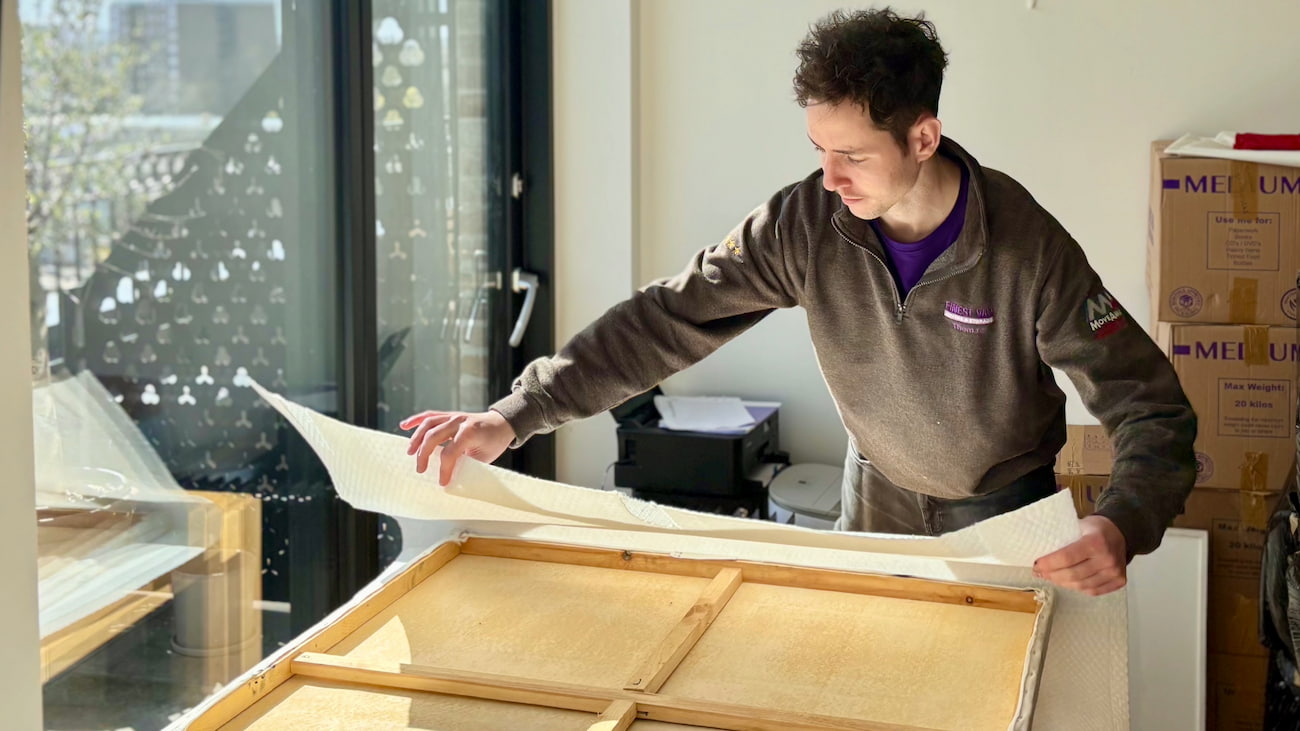 Removals specialist securing canvas artwork for safe transport during a UK house move