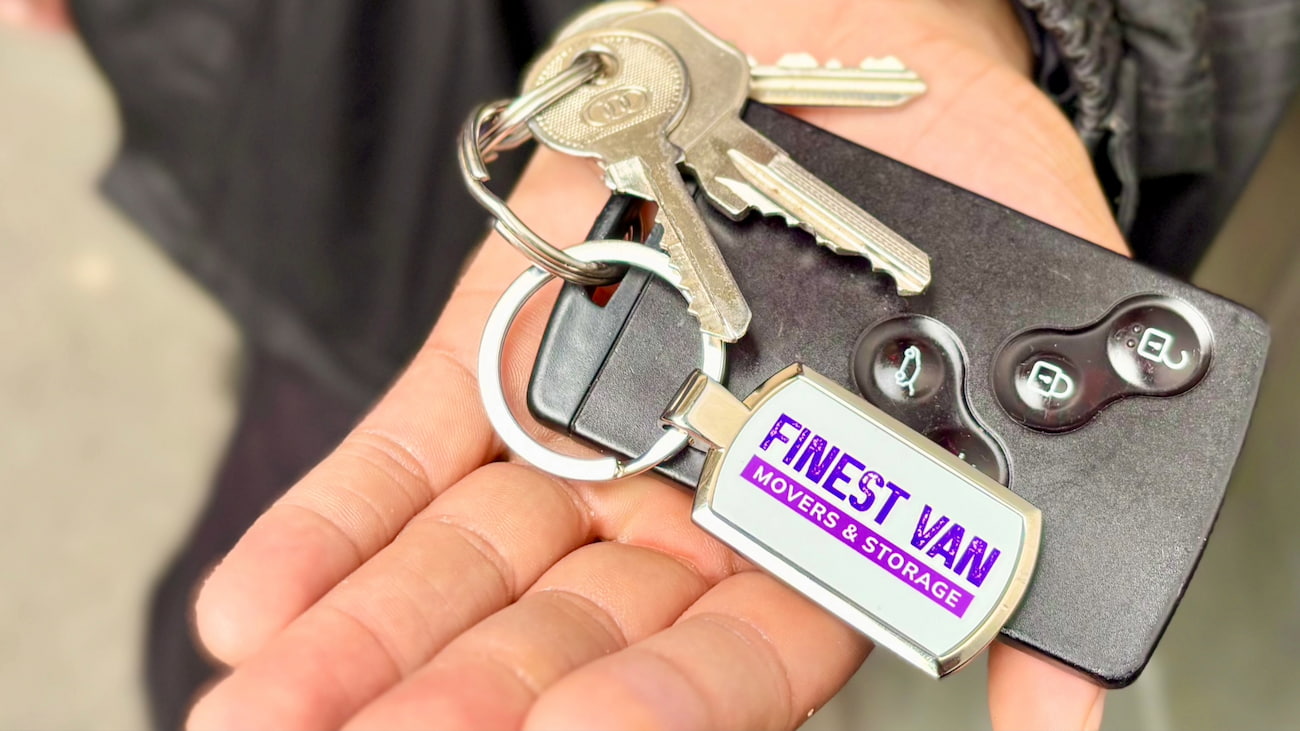 Hand holding house keys during property handover on moving day in London
