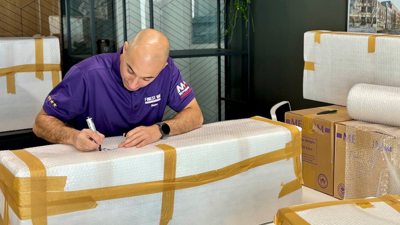 Removals specialist wrapping and labelling office equipment for an office move