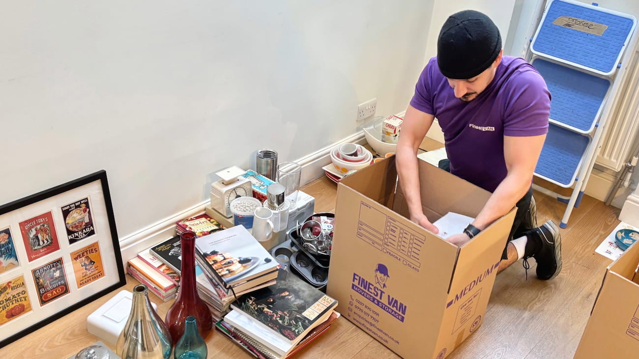 Finest Van removal specialist packing items into a moving box for a house move in South London