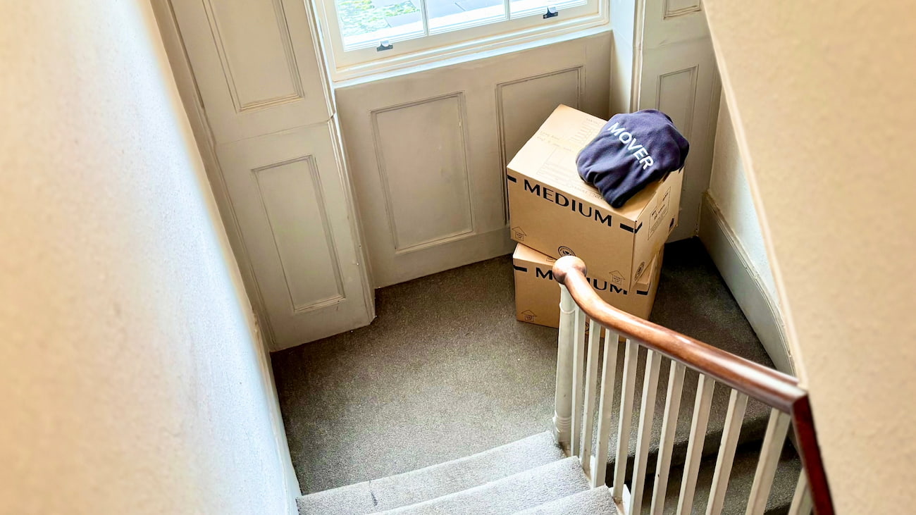 Moving boxes stacked on stair landing during flat move without a lift in London