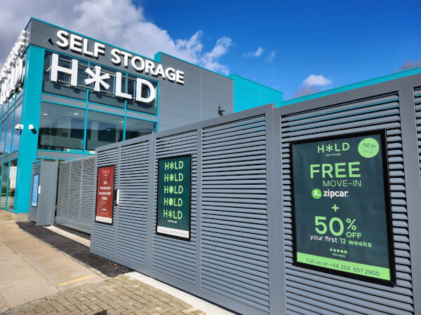 Exterior of HOLD Self Storage in London with branded fencing and main building
